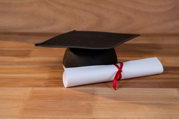 Close-up do certificado de graduação com placa de argamassa sobre uma mesa