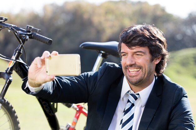 Close-up do executivo que toma uma foto com sua bicicleta