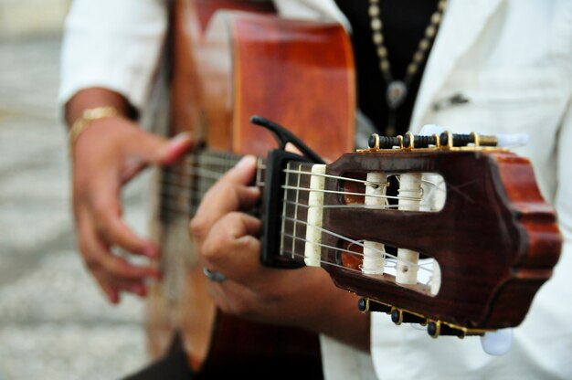 Close-up do homem que joga a guitarra
