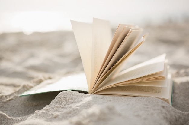 Close-up do livro aberto na areia