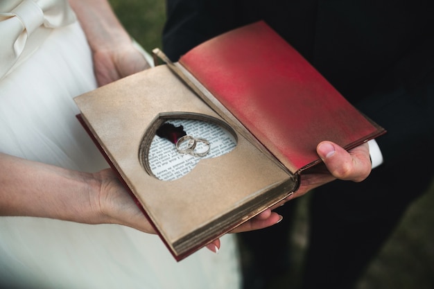 Close-up do livro antigo com os anéis de casamento