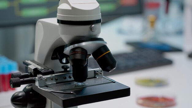 Close-up do microscópio de lente de vidro na mesa do laboratório