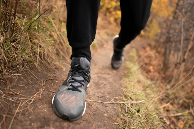 Close-up dos pés do homem na floresta