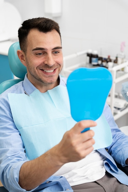 Foto grátis close-up em cliente feliz em clínica dentária