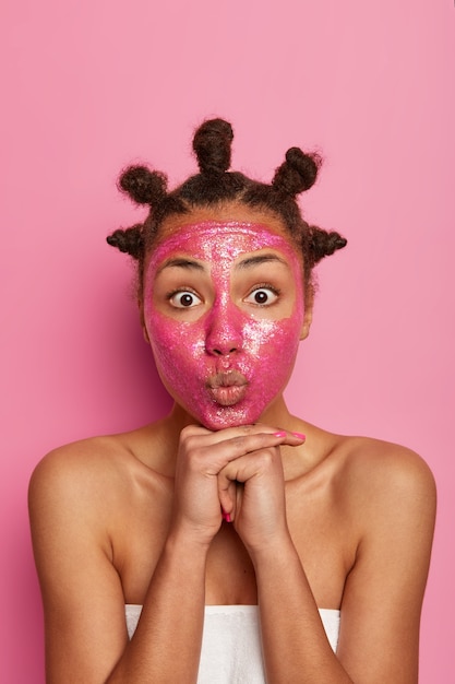 Foto grátis close-up, feliz mulher étnica gosta de aplicar máscara facial isolada