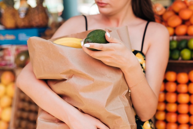 Foto grátis close-up feminino segurando um saco de papel cheio