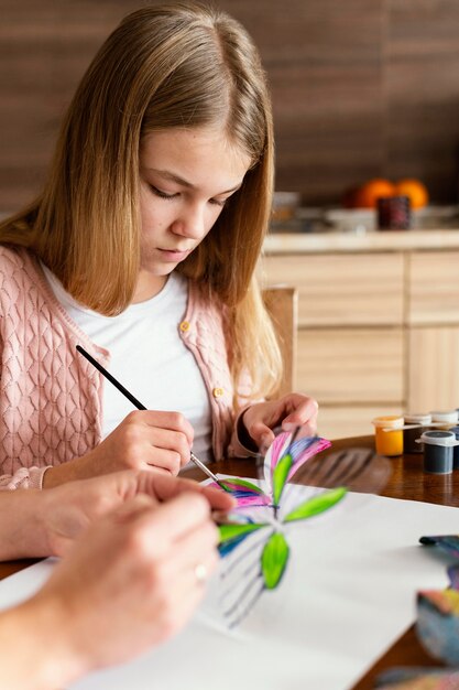 Close-up garota pintando borboleta