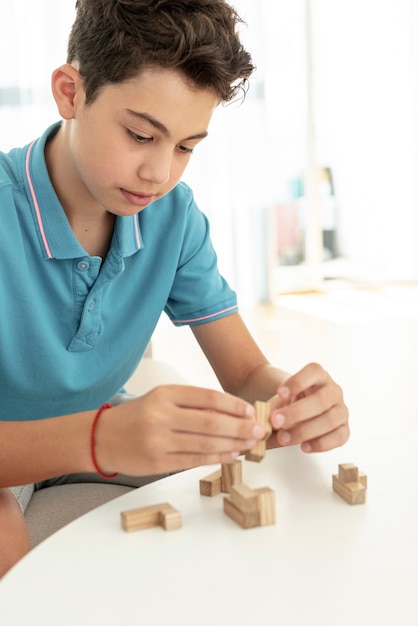 Foto grátis close-up garoto brincando com pedaços de jenga