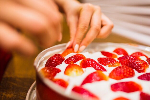Close-up hands decorating cake