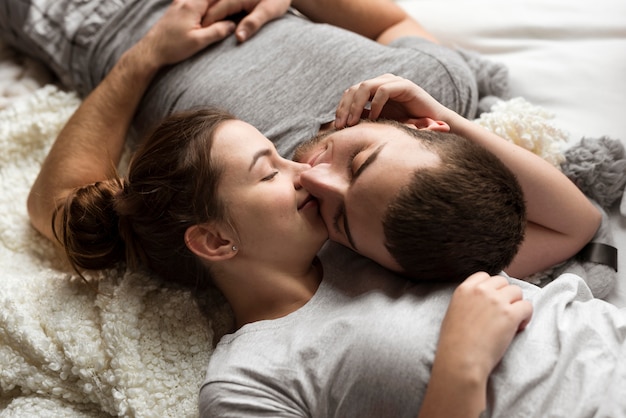 Close-up lindo casal beijando na cama