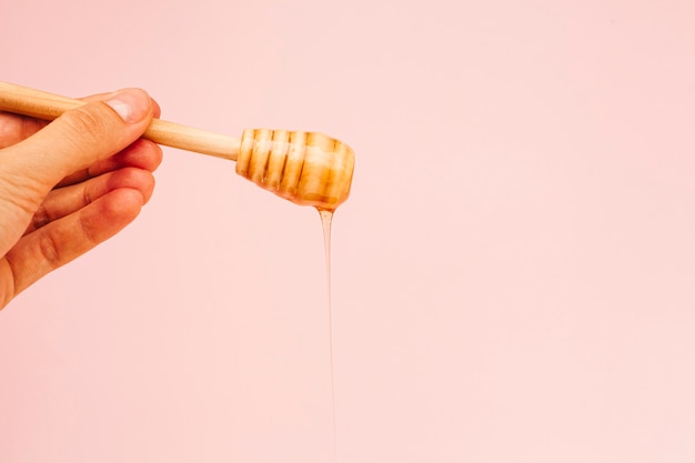 Foto grátis close-up mão segurando o pau de mel saboroso