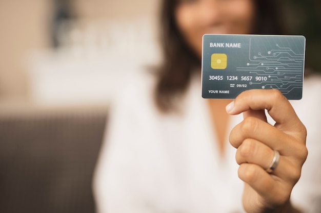 Close-up mão segurando um cartão de crédito simulado Foto Premium