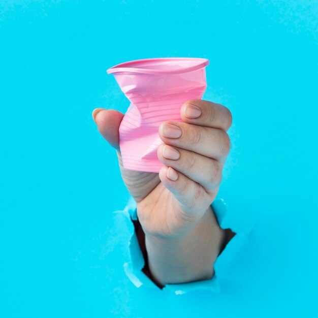 Foto grátis close-up mão segurando um copo de plástico