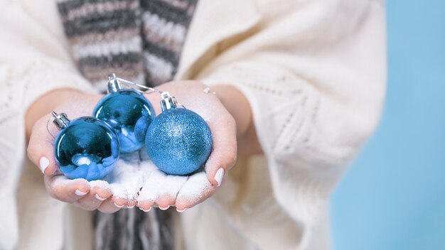 Close-up mãos segurando bolas de Natal