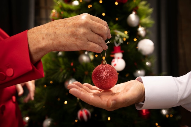 Close-up mãos segurando uma bola de Natal