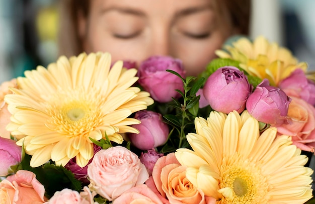 Close-up mulher cheirando flores