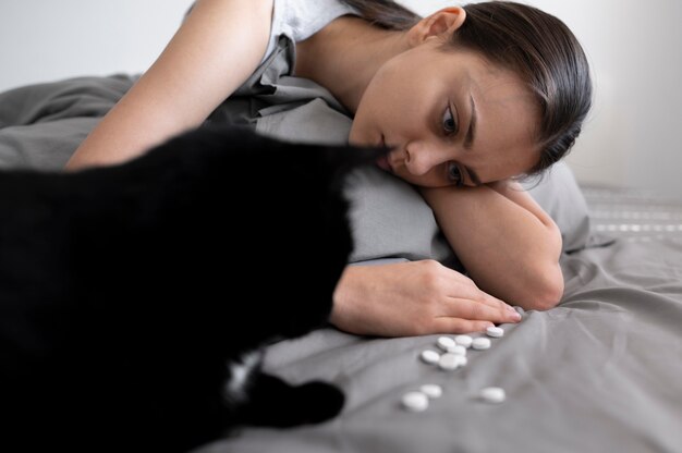 Close-up mulher com gato e comprimidos