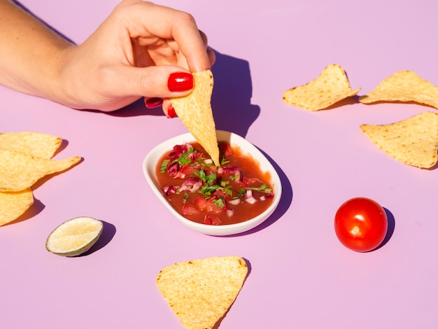 Foto grátis close-up mulher com tortilla chips e molho