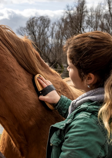 Close-up mulher escovando o cavalo