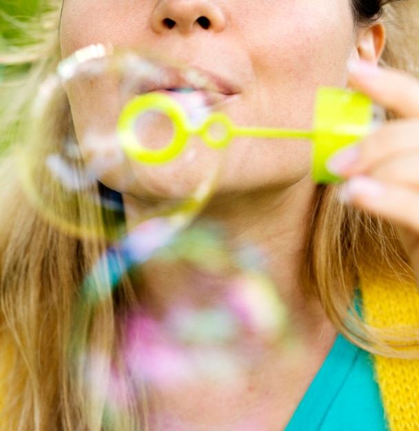 Close-up mulher fazendo bolhas de sabão