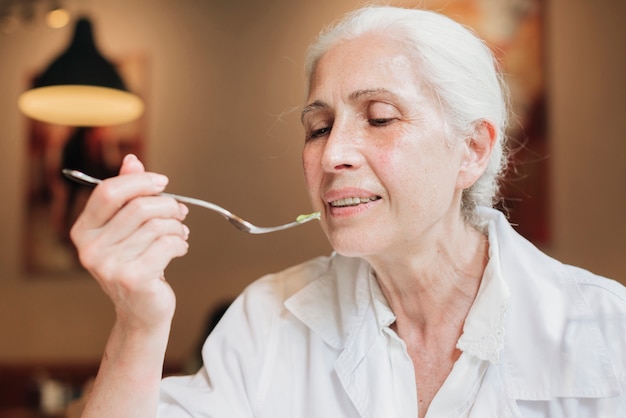 Close-up, mulher velha, comer, em, restaurante