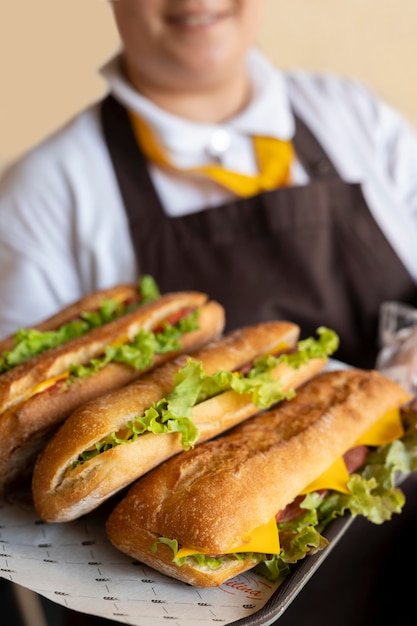 Close-up no jovem chef segurando sanduíches