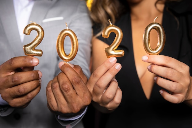 Foto grátis close-up pessoas segurando velas com o novo ano 2020