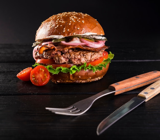 Foto grátis close-up pronto para ser servido hambúrguer com talheres