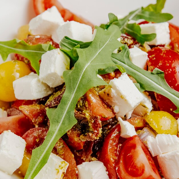 Close-up salada com queijo feta, tomate seco e rúcula