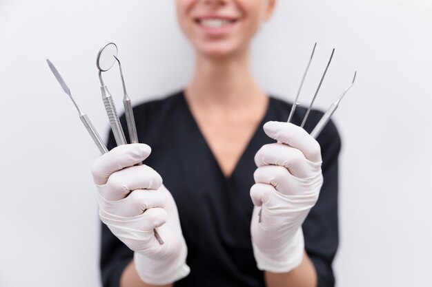 Close-up sorridente dentista segurando ferramentas