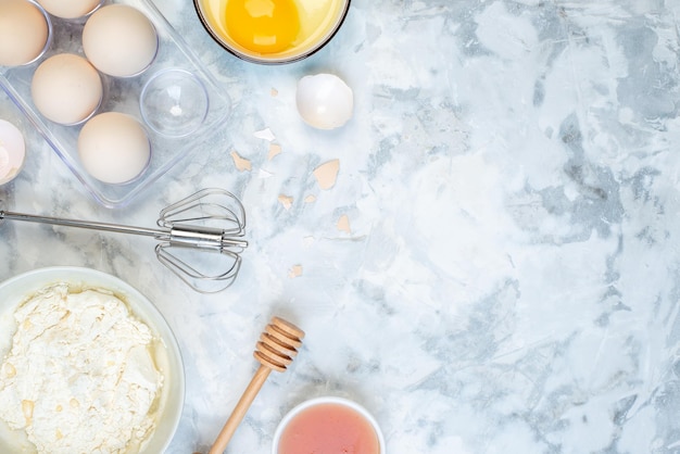 Foto grátis close-up vista de farinha branca em uma tigela e geléia de ovos de ferramenta de cozinha inoxidável no lado direito em fundo de dois tons