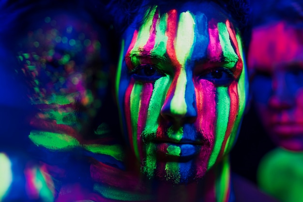 Close-up vista do homem com maquiagem fluorescente colorida