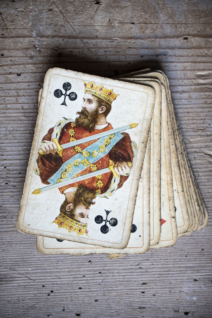 Foto grátis close vertical de cartas de jogar velhas e desgastadas em uma mesa de madeira