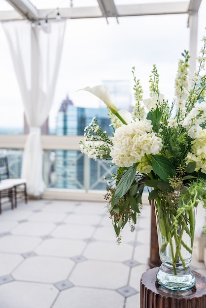 Close vertical de um lindo buquê com flores brancas em um vaso de vidro