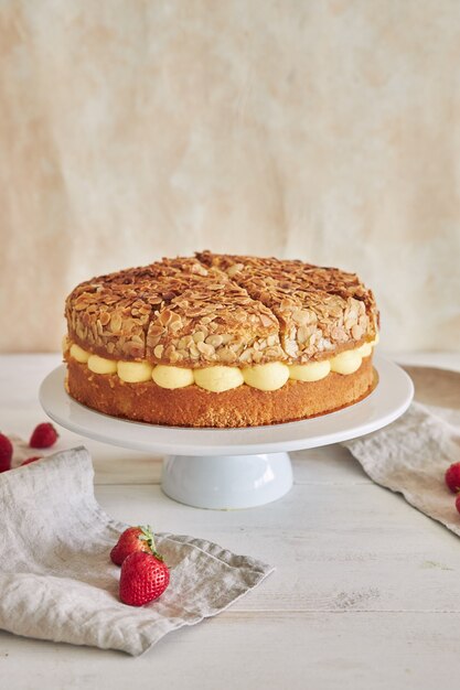 Close vertical do delicioso bolo de creme de baunilha com morangos dentro em uma mesa branca