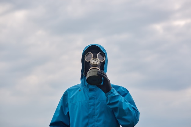 Closeup cientista químico ou ecologista posando ao ar livre, vestidos de uniforme azul e respirador, cientista explora os arredores, apela para proteger nosso meio ambiente. conceito de ecologia.