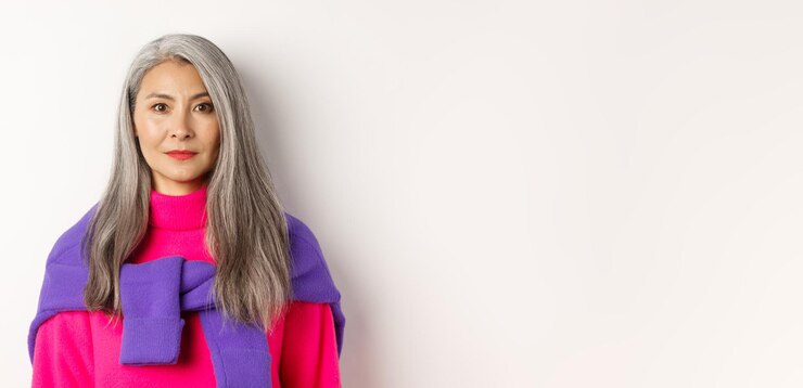 Foto grátis closeup da mulher elegante com cabelos grisalhos e sem rugas sorrindo e olhando para a câmera em pé no tr