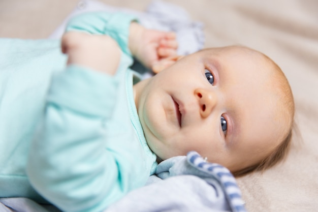 Foto grátis closeup de calmo doce bebê deitado na capa de cama