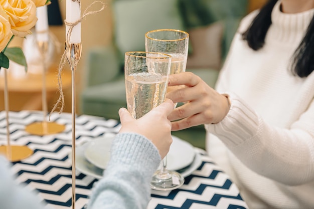 Closeup de copos com champanhe nas mãos femininas