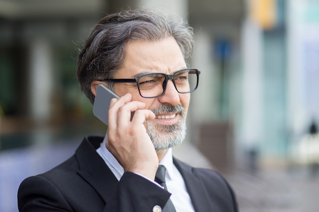 Closeup de homem de negócios de meia-idade chamando o telefone