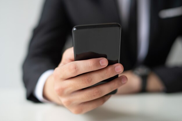 Closeup de homem de negócios, mantendo e usando o smartphone