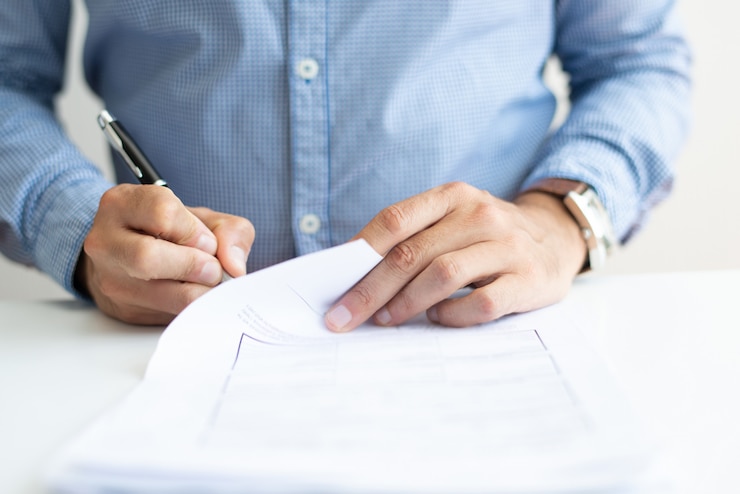 Homem assinando o novo contrato social, após uma alteração contratual.