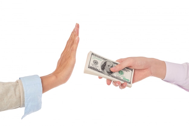 Closeup de mãos femininas, estendendo uma pilha de notas de dólar para as mãos masculinas, gesticulando como se rejeitando o dinheiro