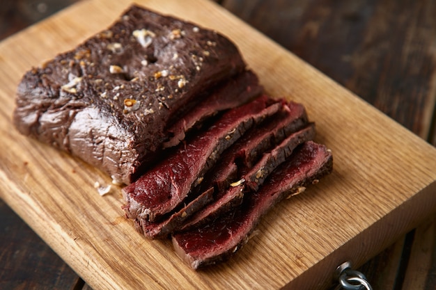 Foto grátis closeup de mesa de madeira fatiada de carne de baleia cozida mal passada