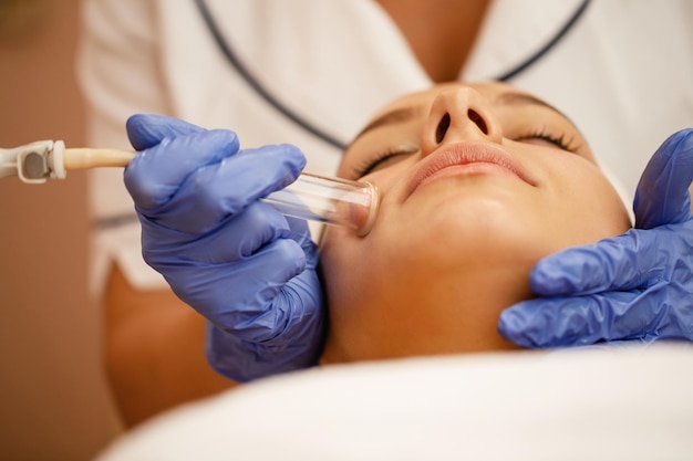 Closeup de mulher tendo tratamento facial a vácuo no spa de beleza