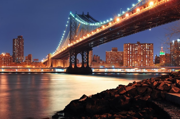 Closeup de New York City Manhattan Bridge com skyline do centro sobre East River.