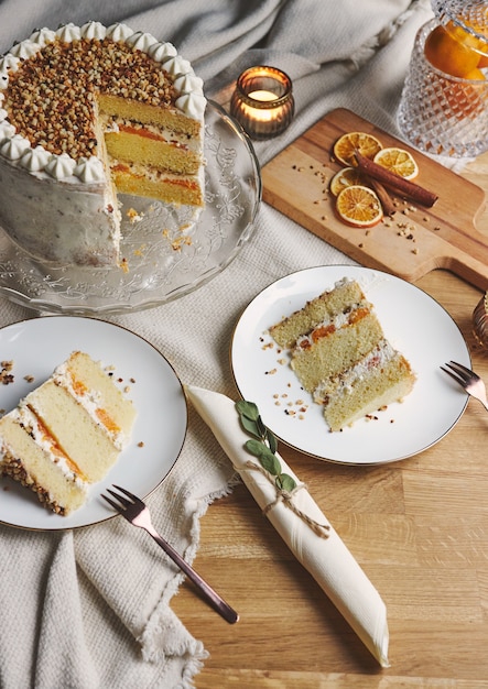 Closeup de pedaços de bolo branco delicioso com nozes e tangerina