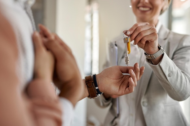 Closeup de um casal recebendo as chaves de seu novo apartamento do agente imobiliário