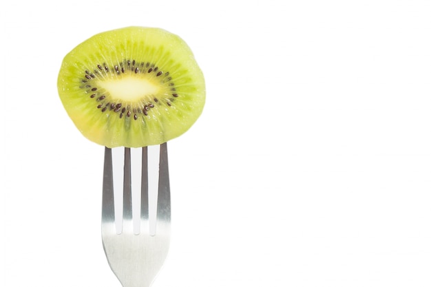 Foto grátis closeup de um pedaço de kiwi no garfo com espaço da cópia no fundo branco