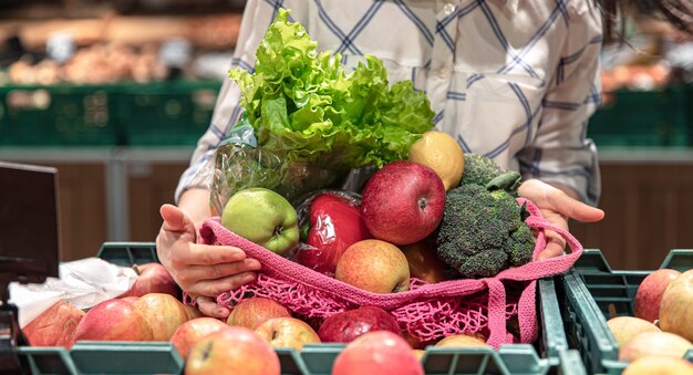 Closeup frutas e legumes em uma sacola de compras em um supermercado